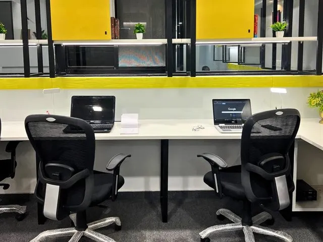 Dedicated desks at Wisdom Cowork, with task chairs and overhead storage